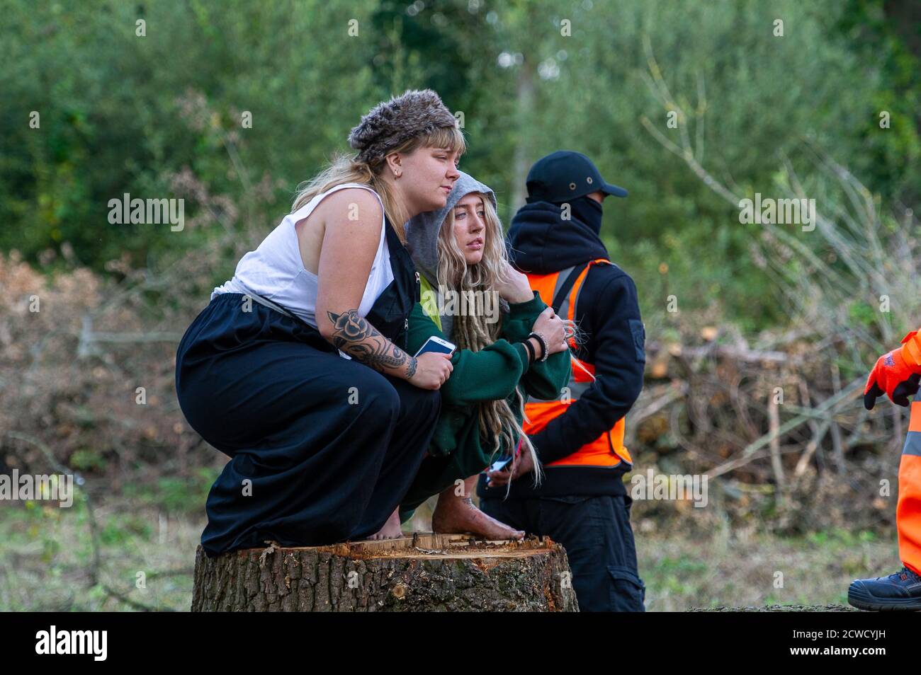 Denham, Royaume-Uni. 29 septembre 2020. Deux jeunes protecteurs d'arbres se réconfortent en regardant les coupe-arbres abattre des arbres pour HS2 aujourd'hui dans le Denham Country Park, dans une zone où les protège-arbres HS2 Rebellion sont publics et à l'extérieur de la zone dans laquelle HS2 est autorisé à travailler. Environ 28 agents NET Enforcement et agents de sécurité HS2 ont empêché les protecteurs d'arbre de regarder l'évolution de la destruction des arbres. Les travaux de construction du HS2 mettent en péril 693 sites fauniques, 108 anciennes terres boisées et 33 ISSS. Crédit : Maureen McLean/Alay Live News Banque D'Images