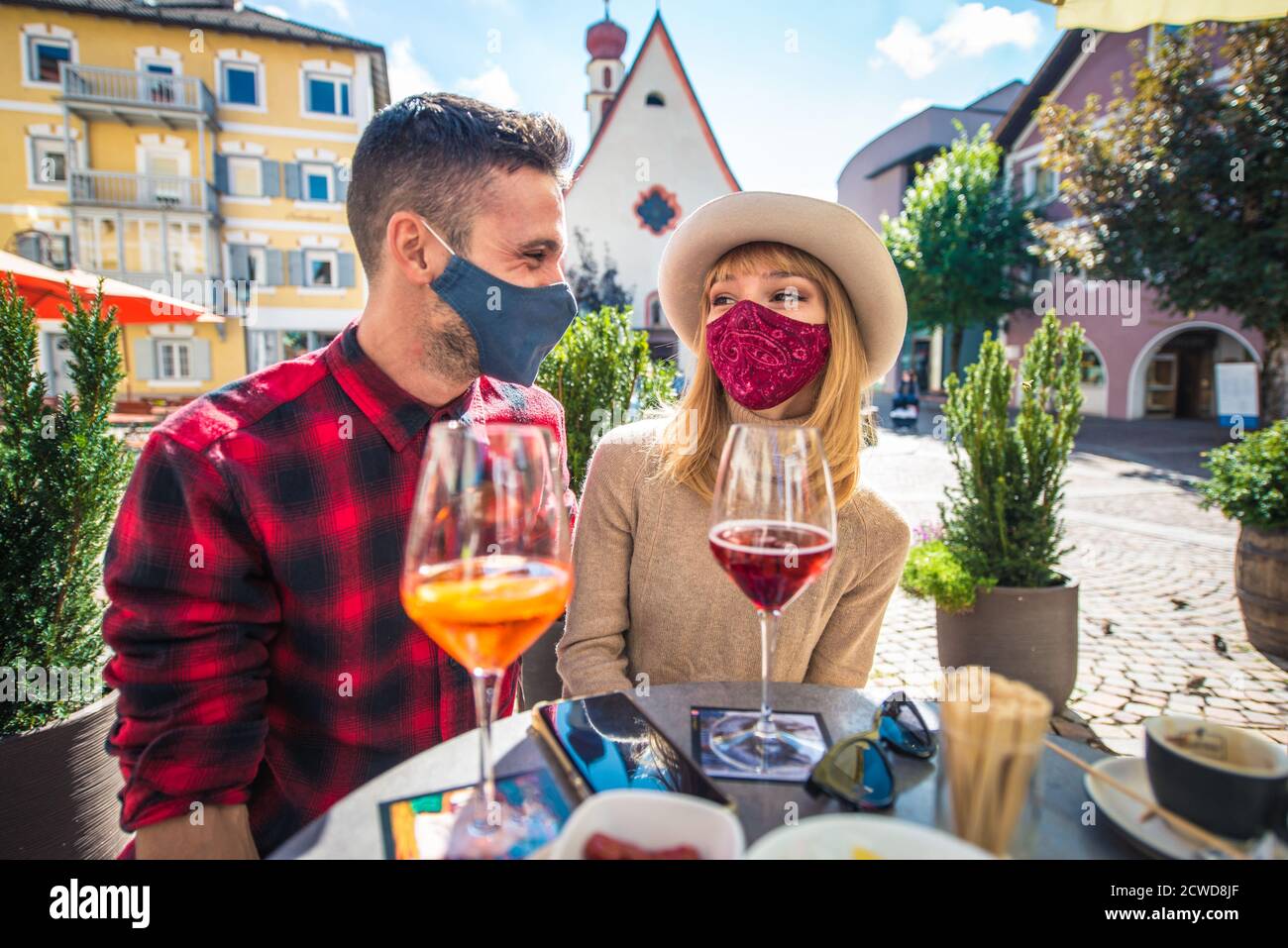 Couple heureux prenant un apéritif dans un café. Homme et femme en lune de miel voyage sur les dolomites italiens. Visite d'un village traditionnel dans une montagne Banque D'Images
