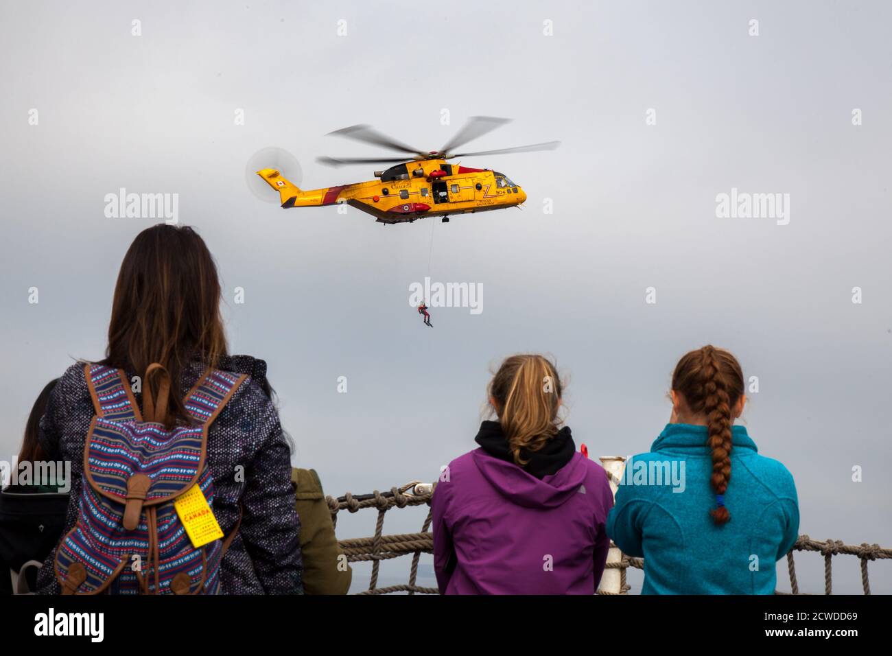 À bord d'un navire de guerre de la base des Forces canadiennes à Esquimalt, en Colombie-Britannique, un groupe de femmes regarde une démonstration de recherche et de sauvetage d'un CS Banque D'Images