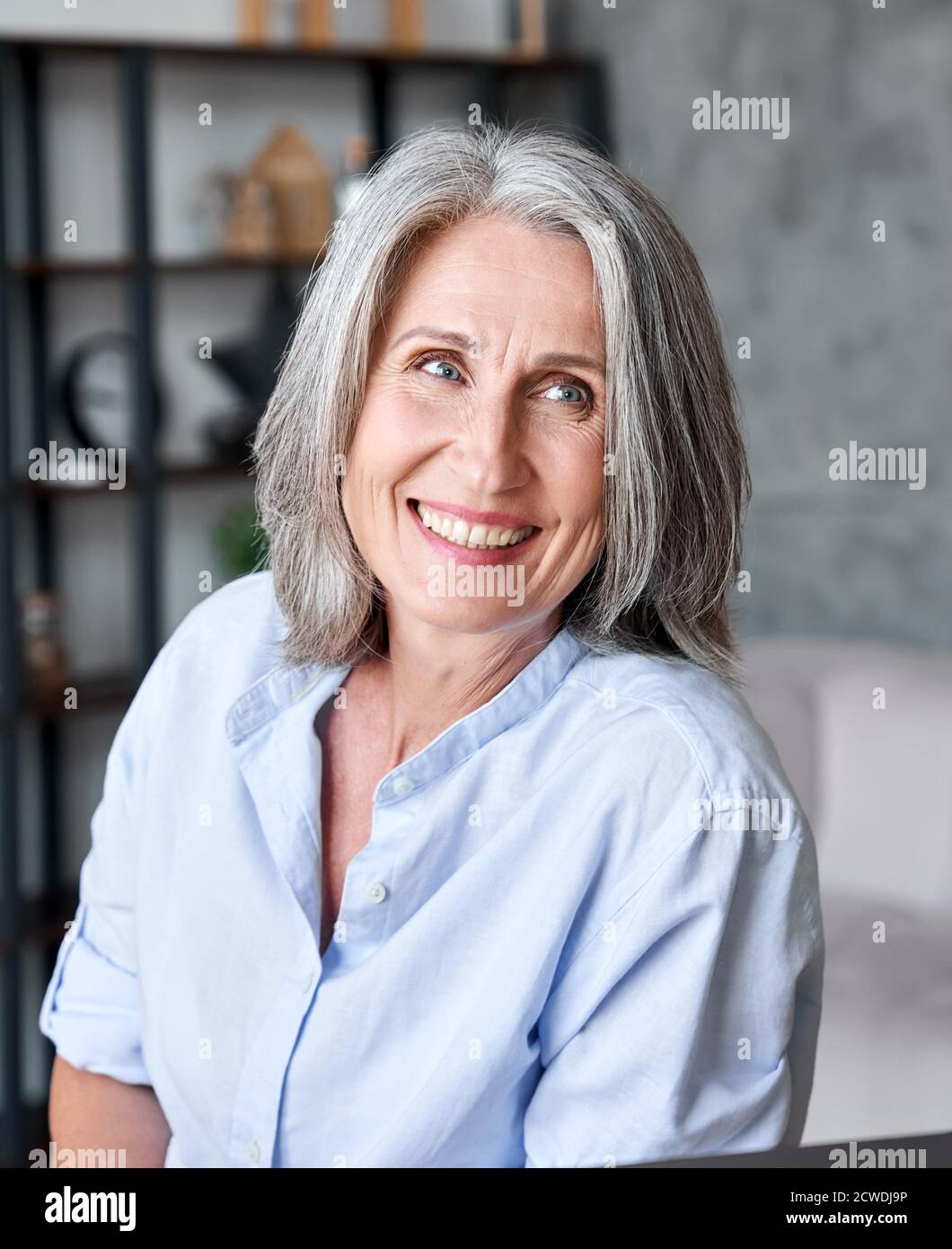 Bonne belle femme d'affaires souriante qui regarde loin dans le bureau. Banque D'Images