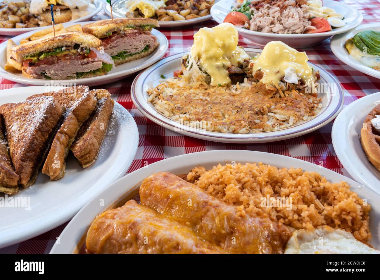 Des portions généreuses d'une variété de choix de petit-déjeuner à thème latino plein de saveurs délicieuses sur une table à carreaux. Banque D'Images