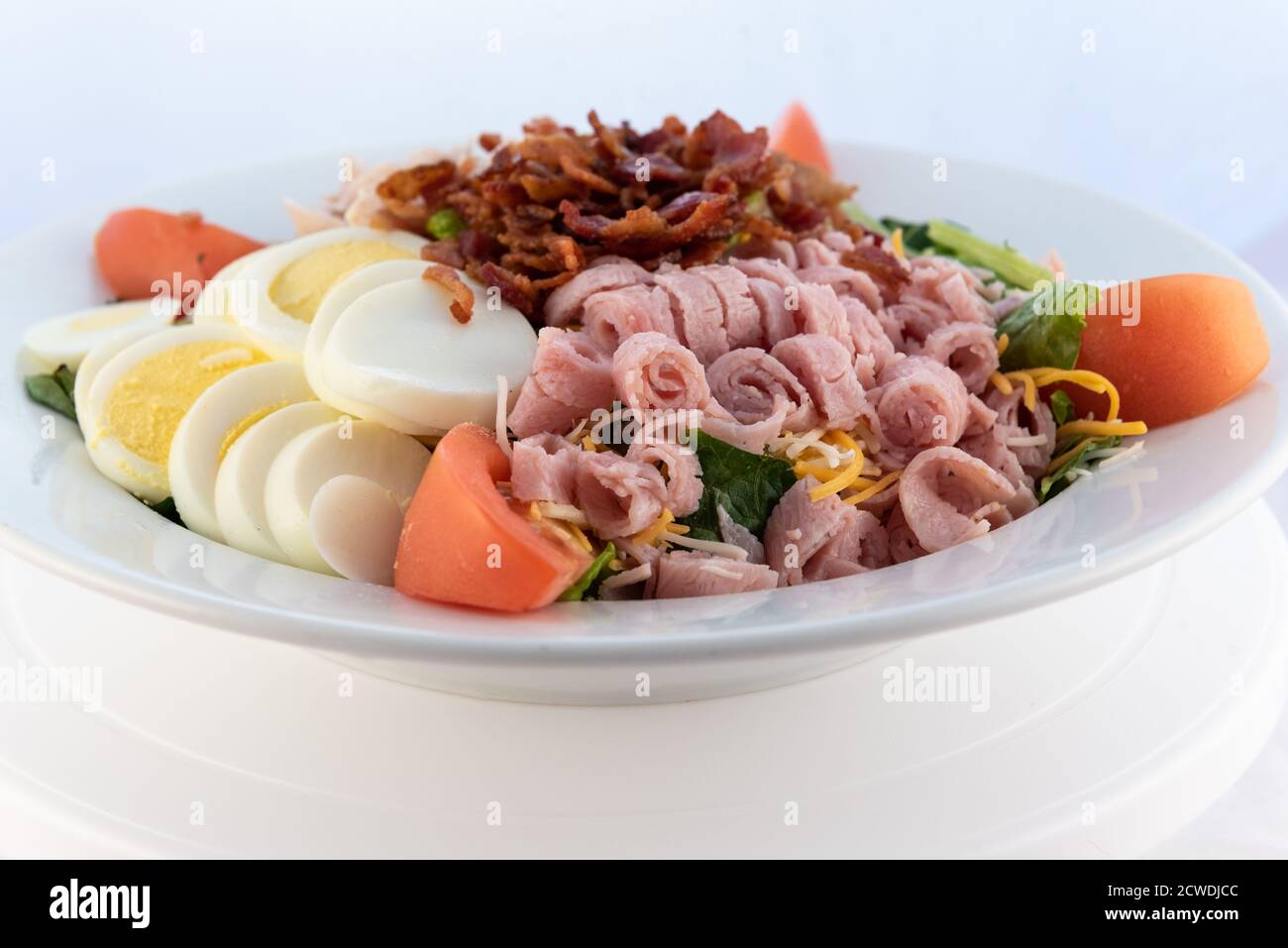 Copieux repas de service d'une salade de petit déjeuner copieux chargée de garniture dans un grand bol. Banque D'Images