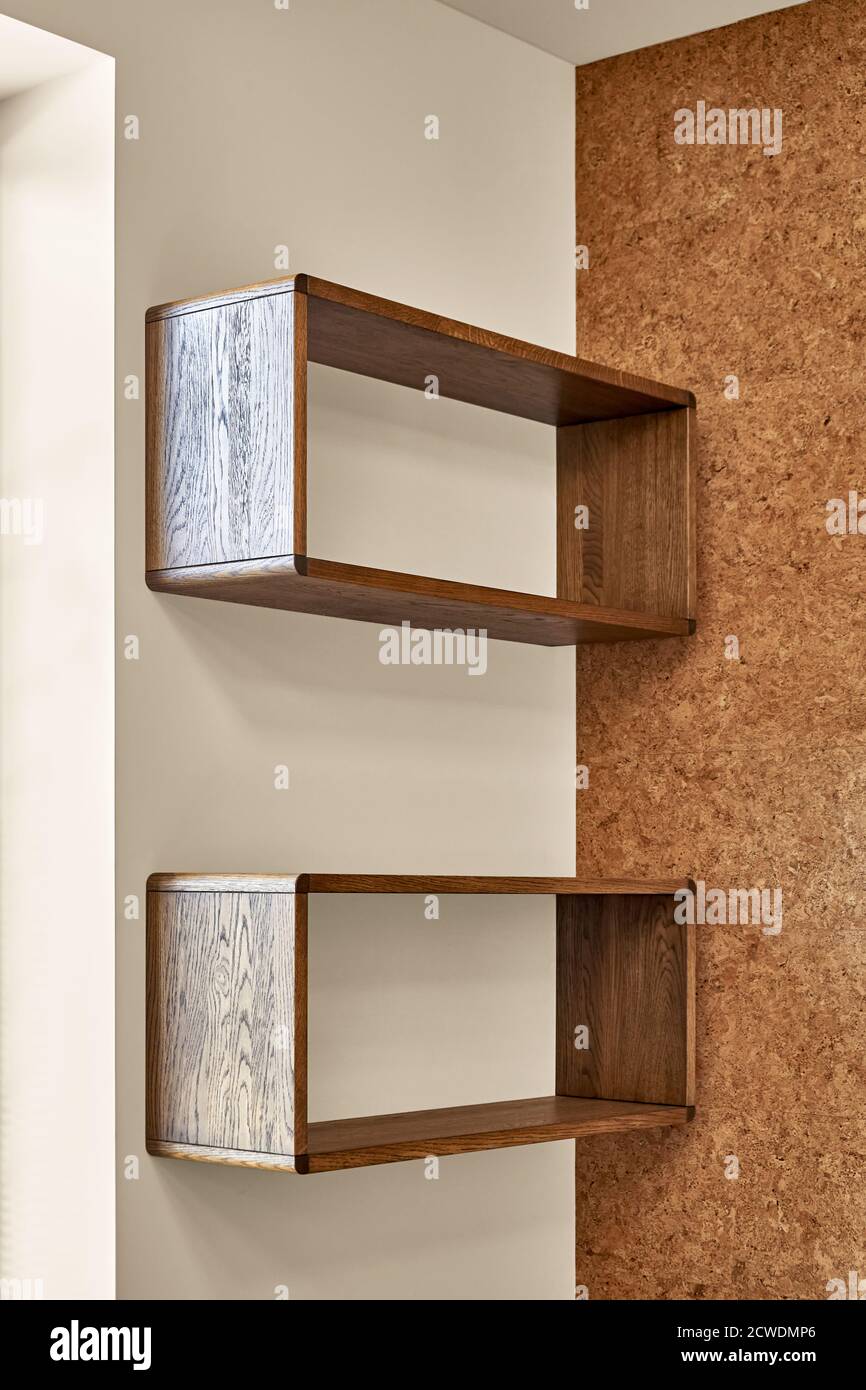 Mobilier moderne étagères en bois fixées au mur sur fond de mur en liège dans la salle de séjour Banque D'Images