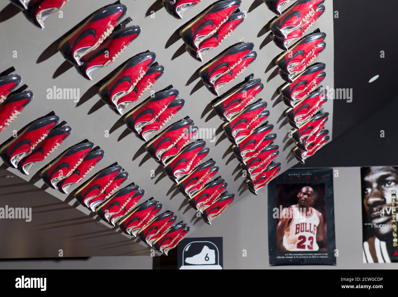 Nike shoes with waffle soles are displayed on a ceiling at the \
