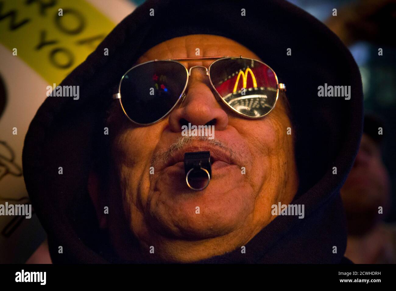 Leonardo Vargas de Brooklyn, un manifestant, dont le logo McDonald's est  reflété dans ses lunettes de soleil, fait siffler lors d'une manifestation  en faveur des employés en grève dans diverses chaînes de