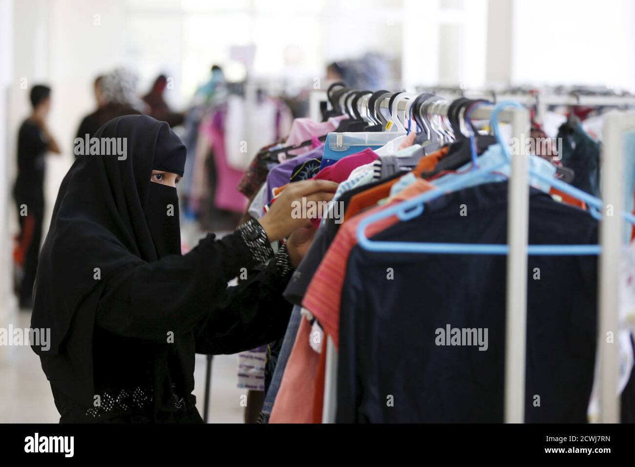 Une femme choisit des vêtements à la Charity Clothing Bank à Amman, en  Jordanie, le 15 juillet 2015, devant Eid al-Fitr. La Banque, l'un des  projets de l'Organisation caritative hachémite jordanienne, vise