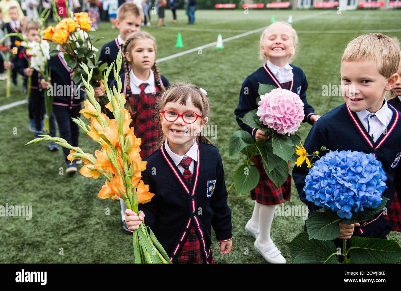 (200930) -- BEIJING, 30 septembre 2020 (Xinhua) -- les enfants assistent à la cérémonie d'ouverture avec des bouquets de fleurs, marquant le début d'une nouvelle année scolaire, au Gymnasium de Vilnius Fabijoniskiu, à Vilnius, en Lituanie, le 1er septembre 2020. (Photo d'Alfredas Pliadis/Xinhua) Banque D'Images