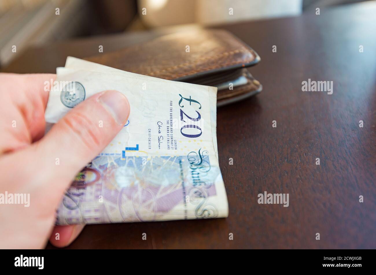 Homme payant des billets de 20 livres dans un café ou un magasin À Londres Banque D'Images