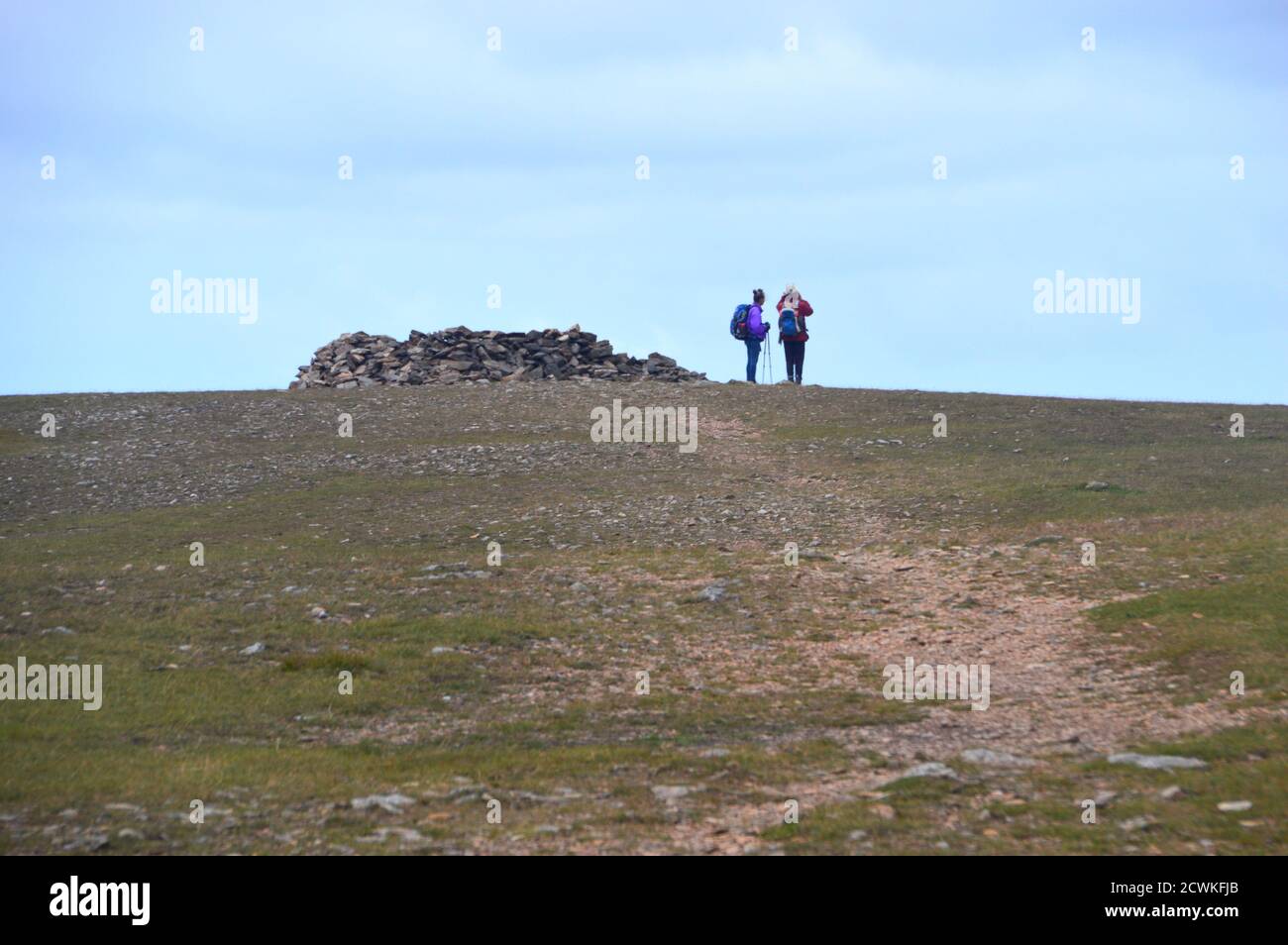 Deux personnes se tenant près du refuge de sommet du Wainwright 'Grasmoor' dans le parc national de Lake District, Cumbria. ROYAUME-UNI. Banque D'Images