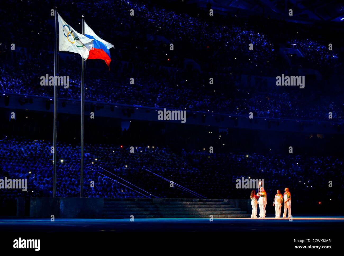 Russian rhythmic gymnast Alina Kabaeva (L) receives the Olympic flame