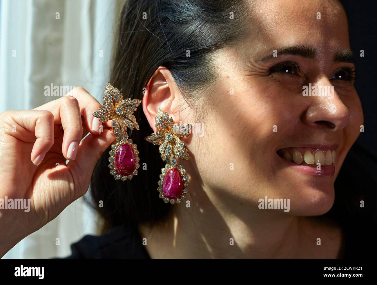 Le personnel d'a Christie tient une paire de pendants d'oreilles rubis et  losanges lors d'une vente aux enchères à Genève, en Suisse, le 8 mai 2015.  Les pendentifs, ainsi qu'une bague correspondante,