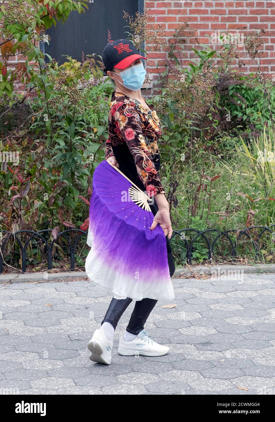 Une danseuse américaine chinoise gracieuse avec un fan de danse de soie à une répétition et une classe de danse traditionnelle. À Queens, New York Banque D'Images