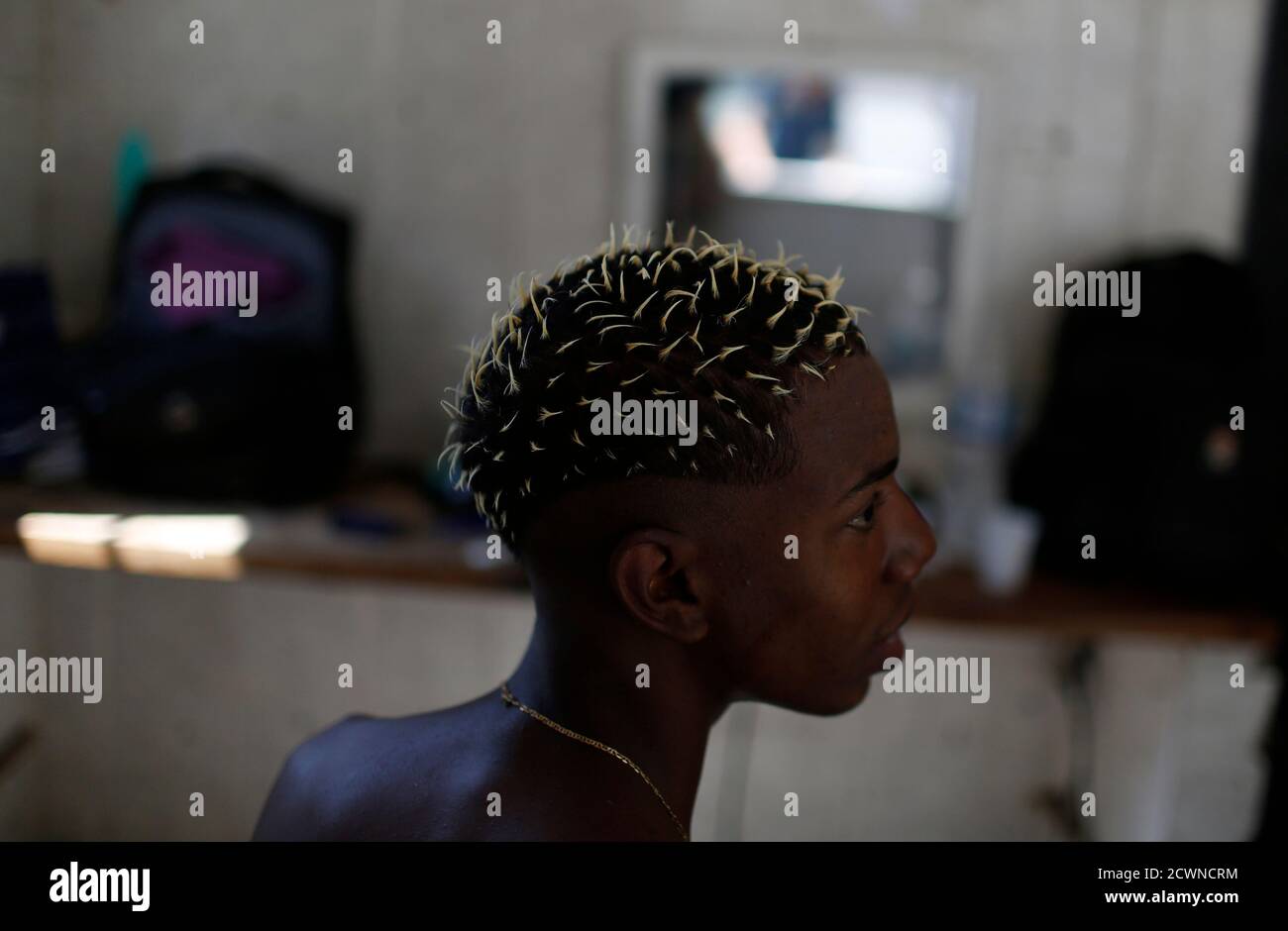 Diogo, a client, talks to his barber after having a dye design on his hair  done at the Barbearia Kengao (barber shop) in a slum in Rio de Janeiro  September 13, 2014.
