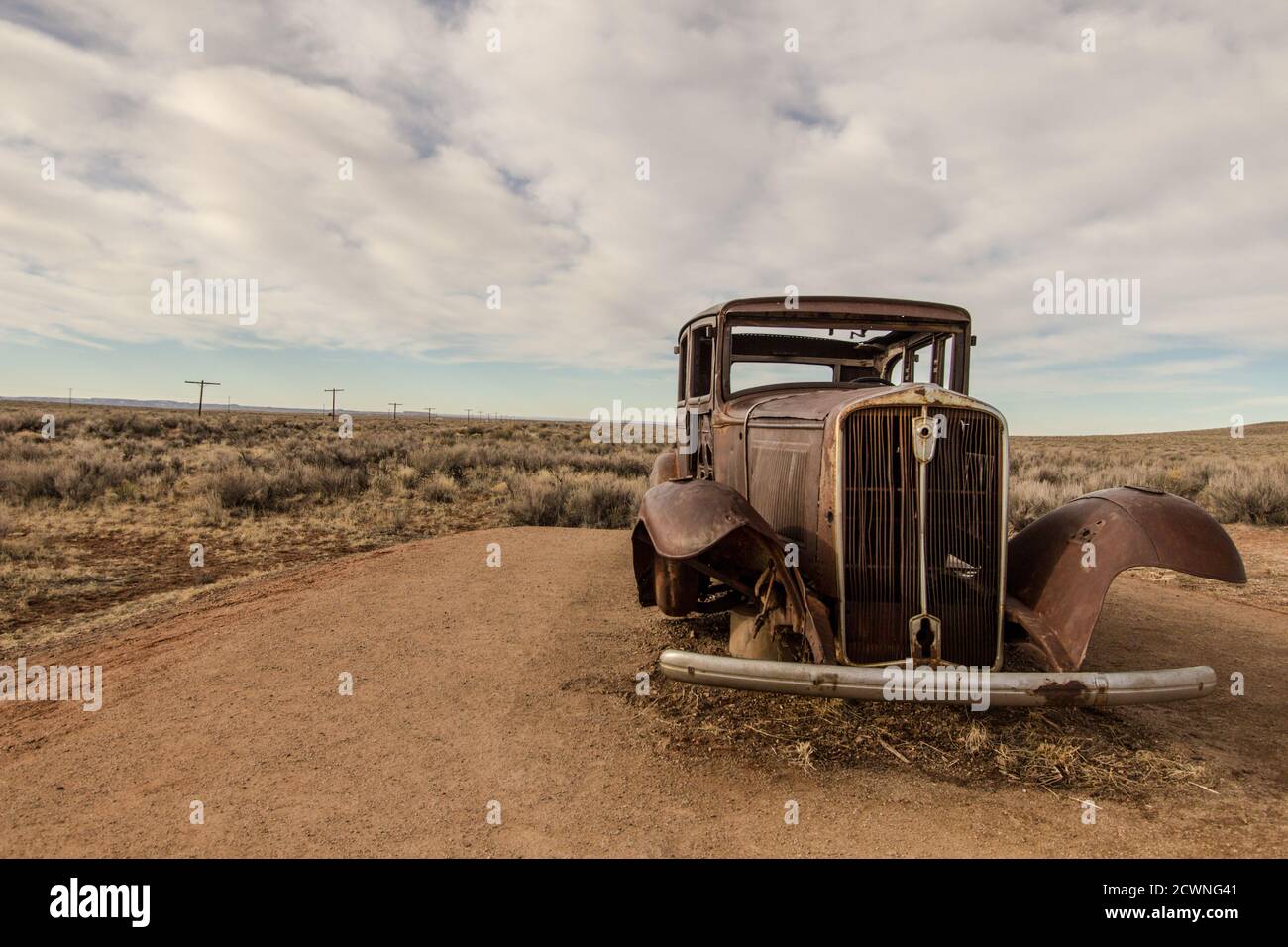 Voiture abandonnée dans le désert américain du sud-ouest au parc national Petrified Forest Painted Desert. Banque D'Images