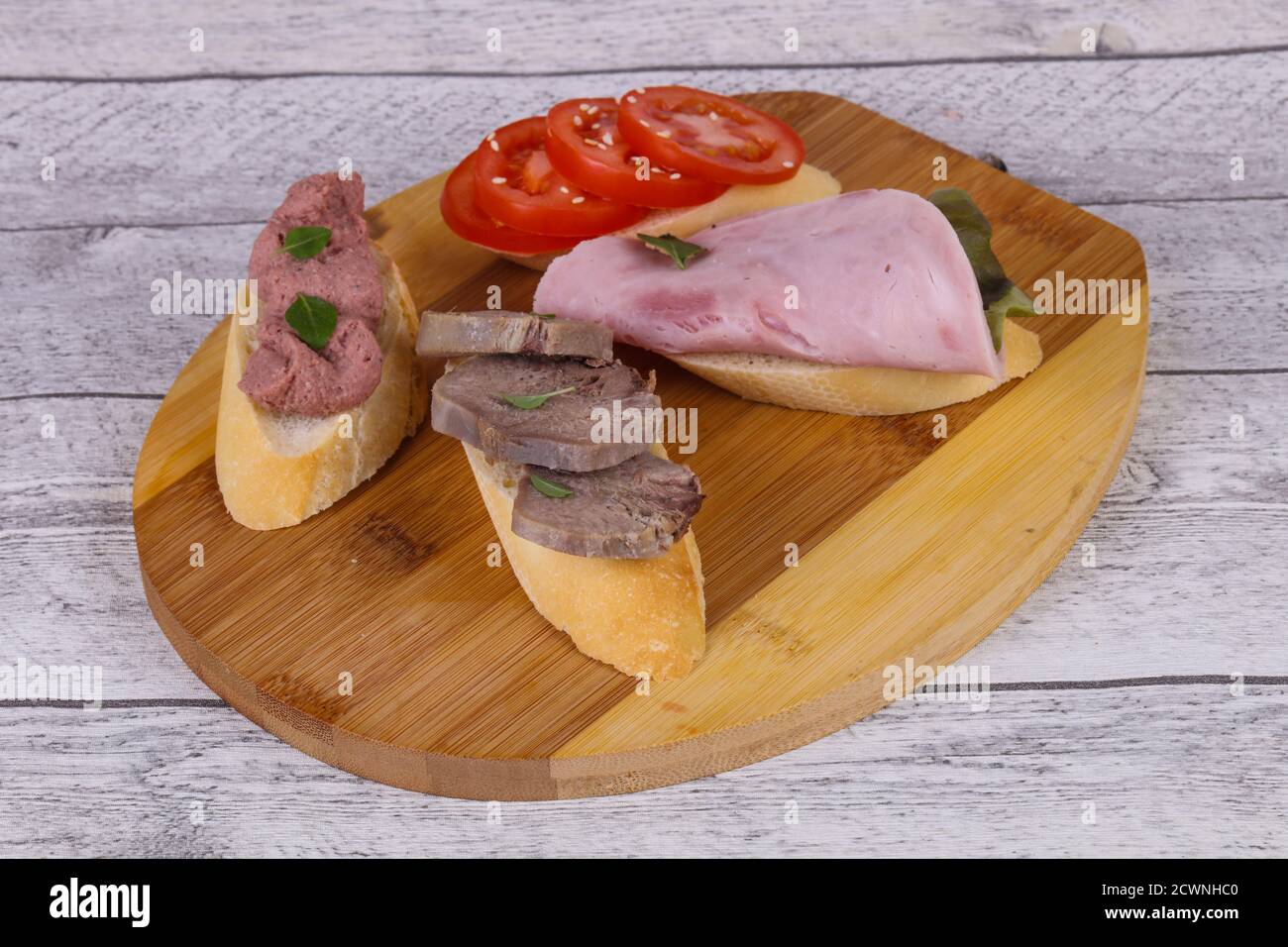 Bruschetta à la tomate, salade de jambon et de la langue a été feuilles et câpres Banque D'Images