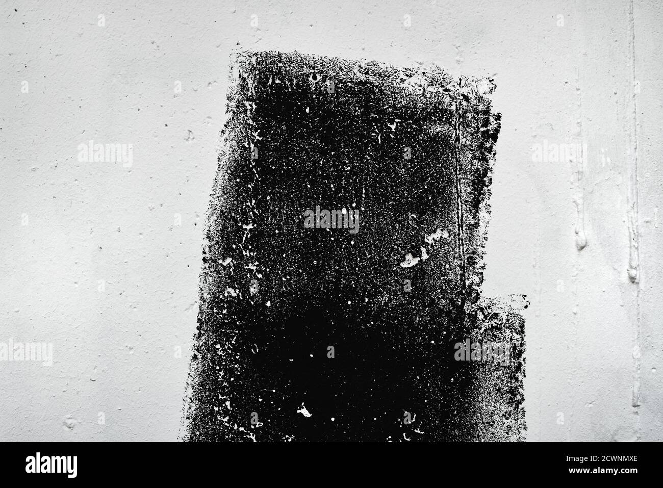 Motif abstrait de texture grunge de peinture noire sur paroi blanche, technique de pinceau sec Banque D'Images