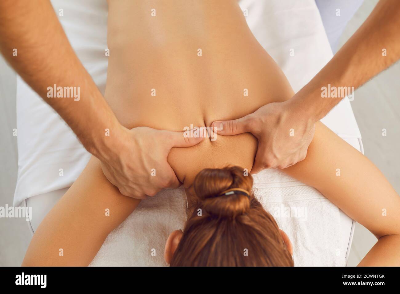 Jeune femme bénéficiant d'un massage professionnel du dos dans une clinique de santé moderne ou centre de spa Banque D'Images
