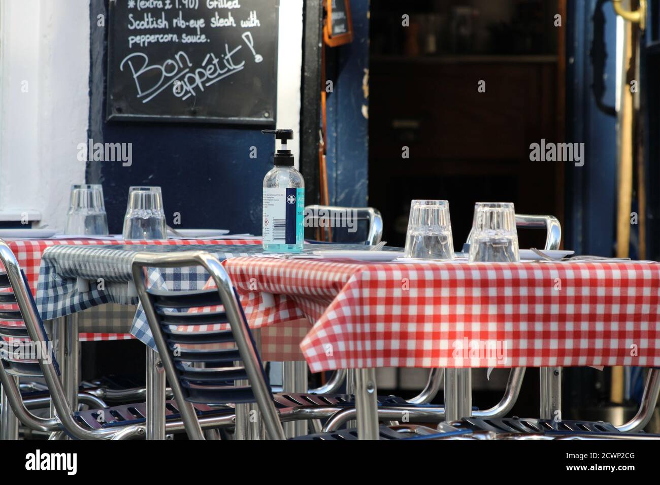 Bouteille de désinfectant pour les mains sur les tables de terrasse du restaurant français Banque D'Images