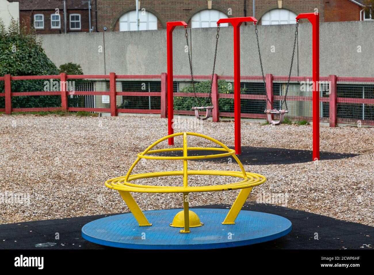 Une aire de jeux pour enfants ou un parc vide montrant un rond-point et balançoires Banque D'Images