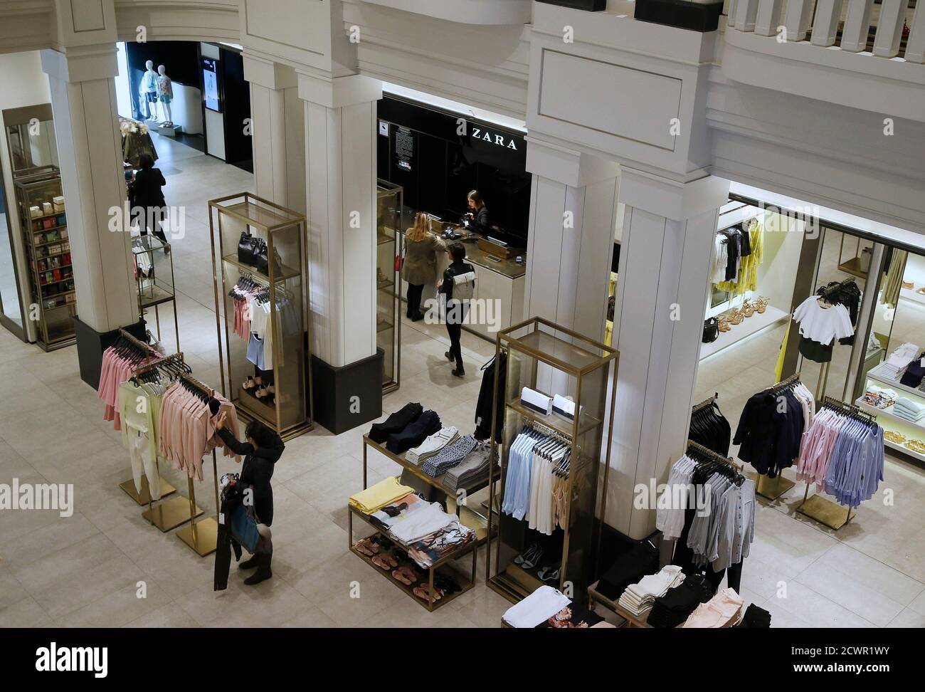 People walk inside a Zara store in central Madrid March 18, 2014. Inditex,  the world's biggest fashion retailer, will accelerate investment in 2014 to  open more new stores after results last year