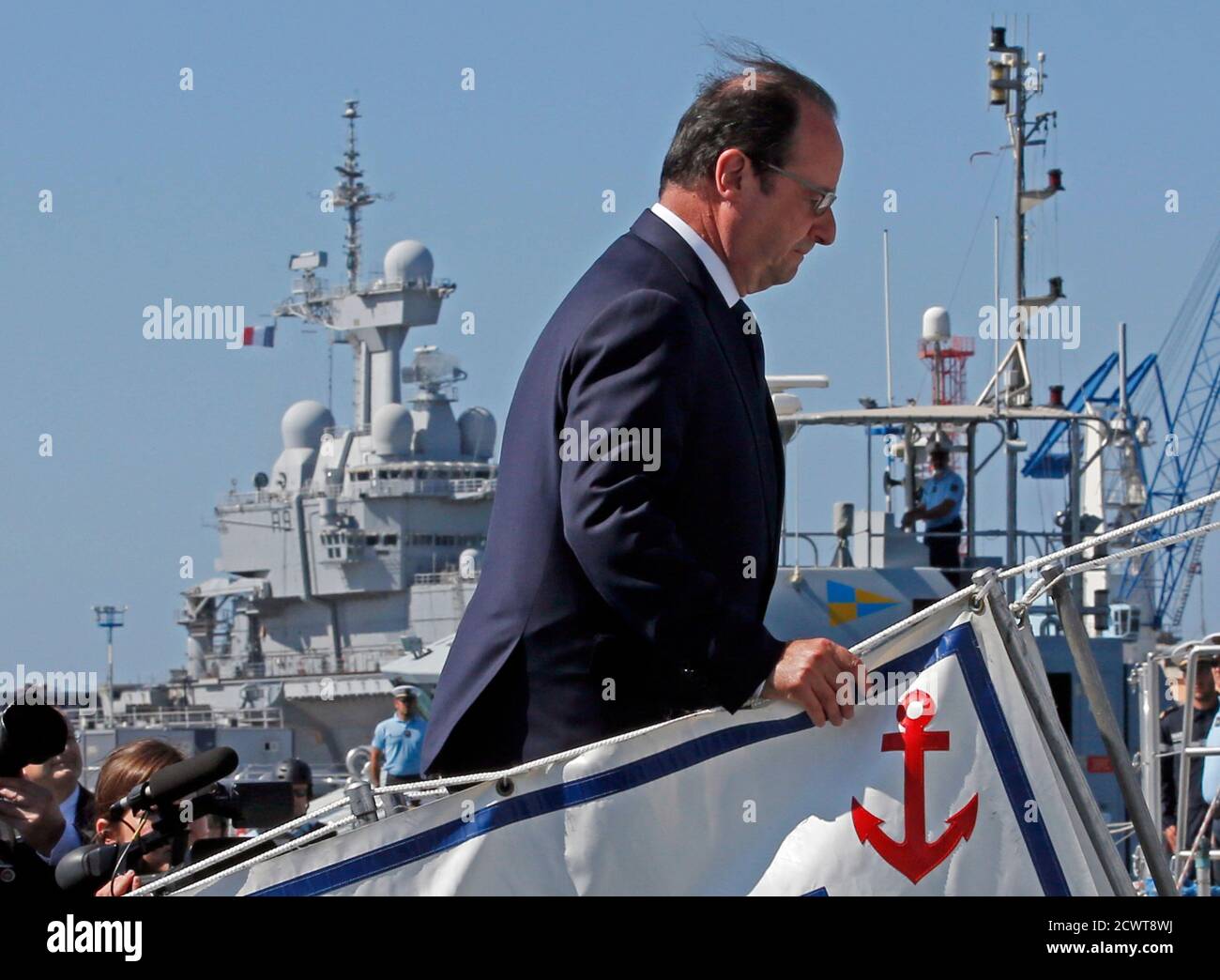 Le président français François Hollande monte à bord d'un bateau militaire  pour assister à un exercice de sécurité lors d'une visite à la base navale  de Toulon, dans le sud-est de la