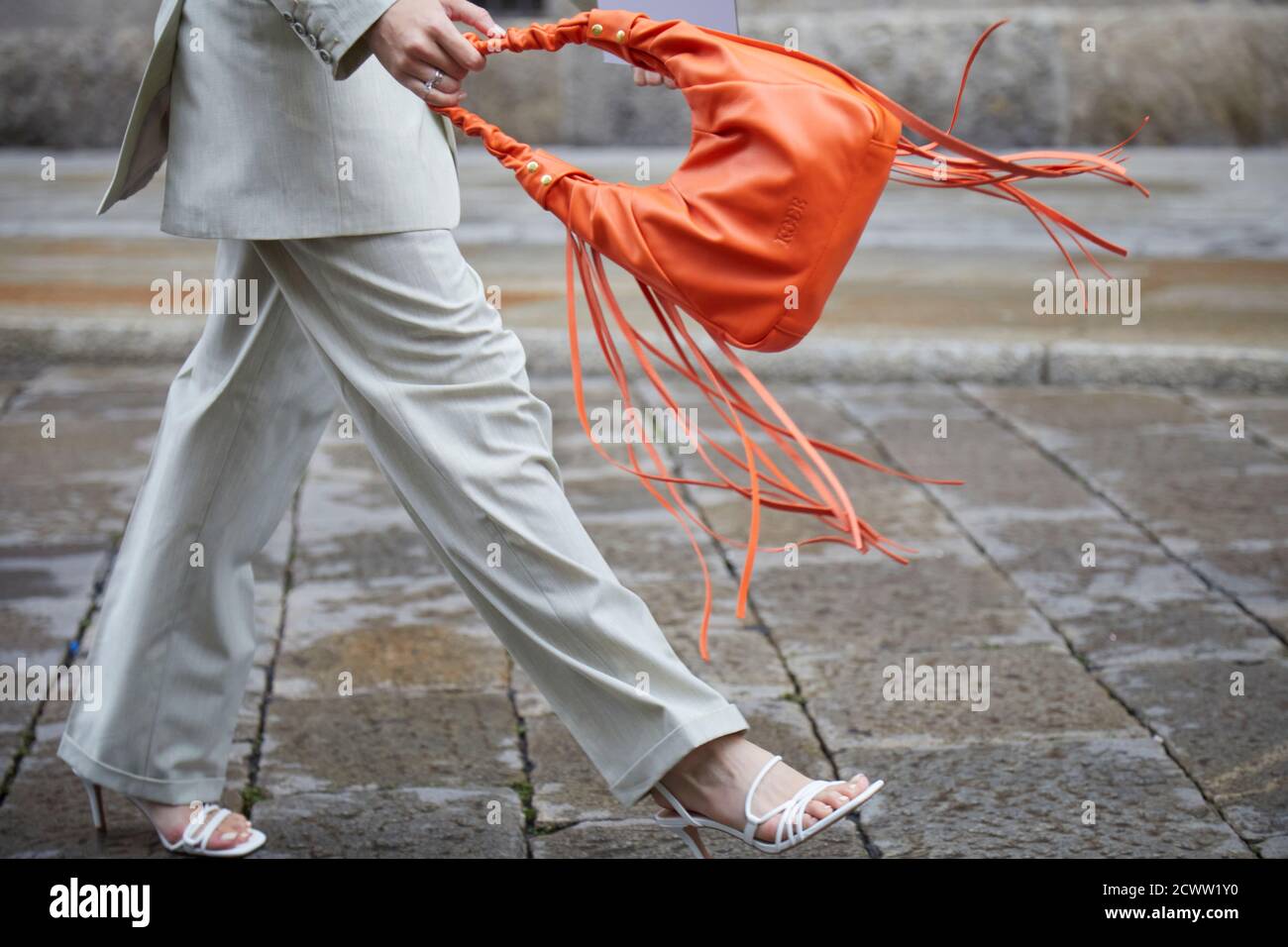 MILAN, ITALIE - 24 SEPTEMBRE 2020: Femme marchant avec sac en cuir orange avec franges avant le spectacle de mode Max Mara, Milan Fashion week Street style Banque D'Images