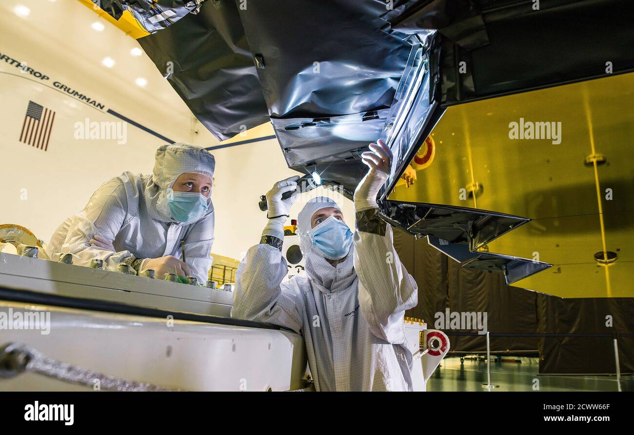 Le télescope spatial James Webb de la NASA utilise un blindage innovant derrière ses miroirs primaires pour bloquer la lumière indésirable, une caractéristique essentielle pour ses observations infrarouges. Le 23 août 2018, les techniciens Ann Meyer (Northrop Grumman) et Larkin Carey (Ball Aerospace) ont inspecté la barrière de protection à l'Institut scientifique du télescope spatial. Banque D'Images