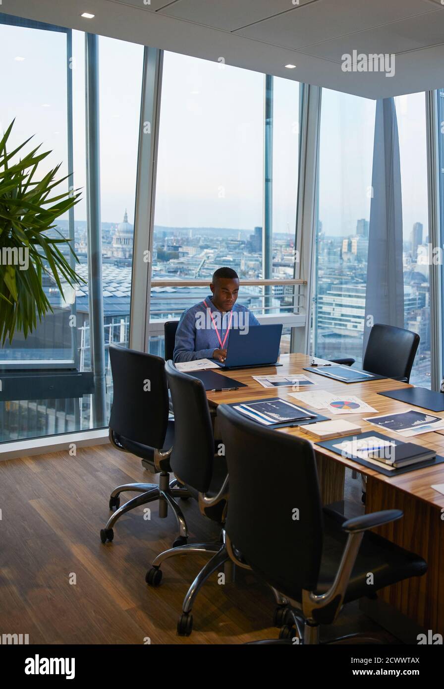 Homme d'affaires travaillant sur un ordinateur portable dans une salle de conférence en hauteur Banque D'Images