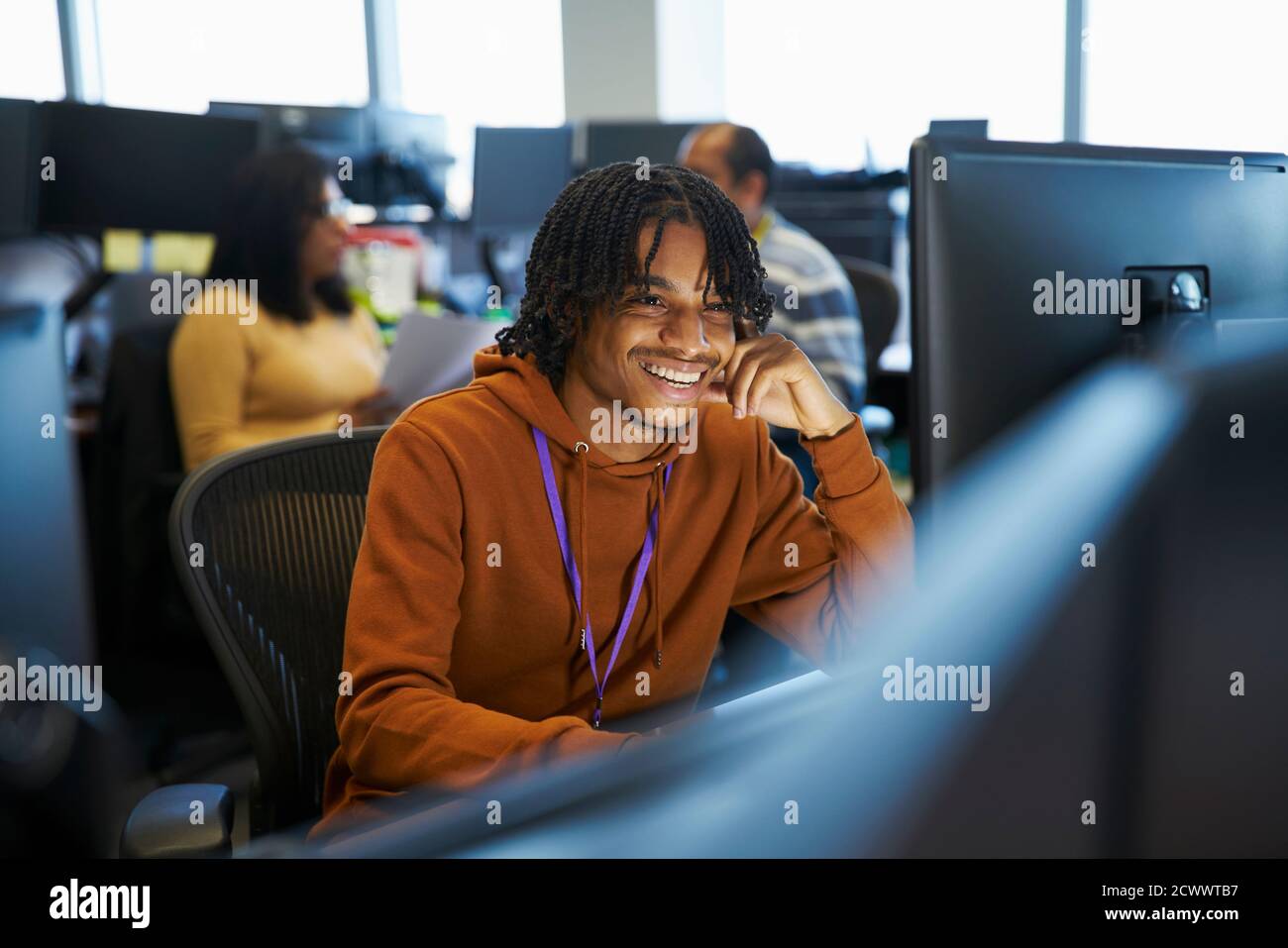 Smiling businessman working at computer in office Banque D'Images