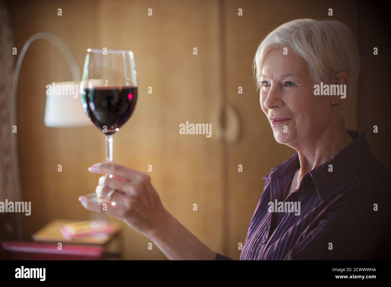 Femme âgée appréciant le vin rouge Banque D'Images