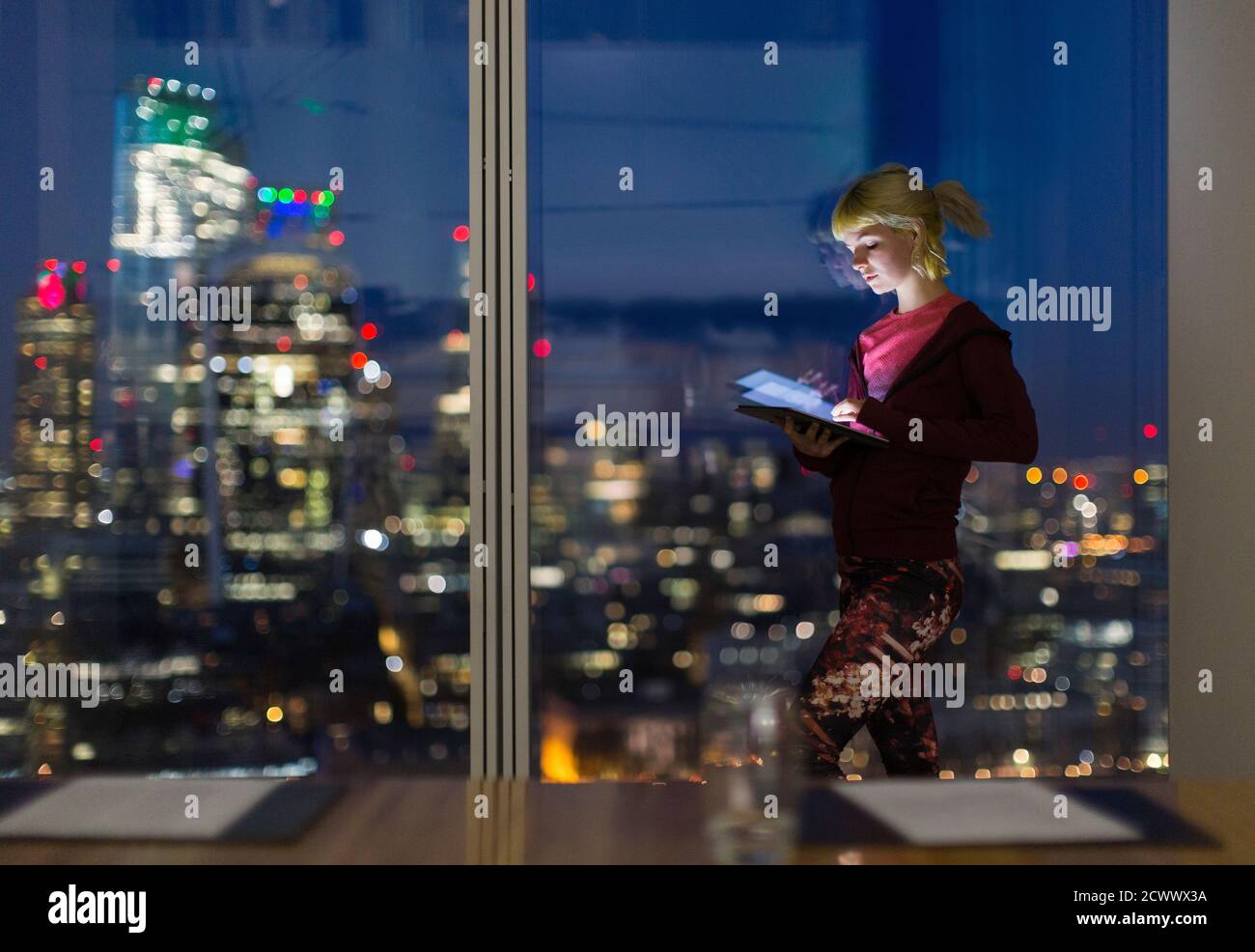 Femme d'affaires avec une tablette numérique travaillant tard dans un bureau haut de gamme Banque D'Images