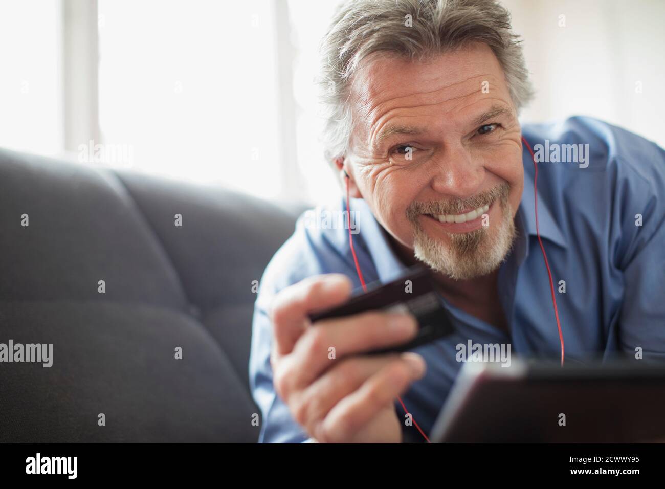 Portrait souriant homme âgé avec casque et carte de crédit Banque D'Images