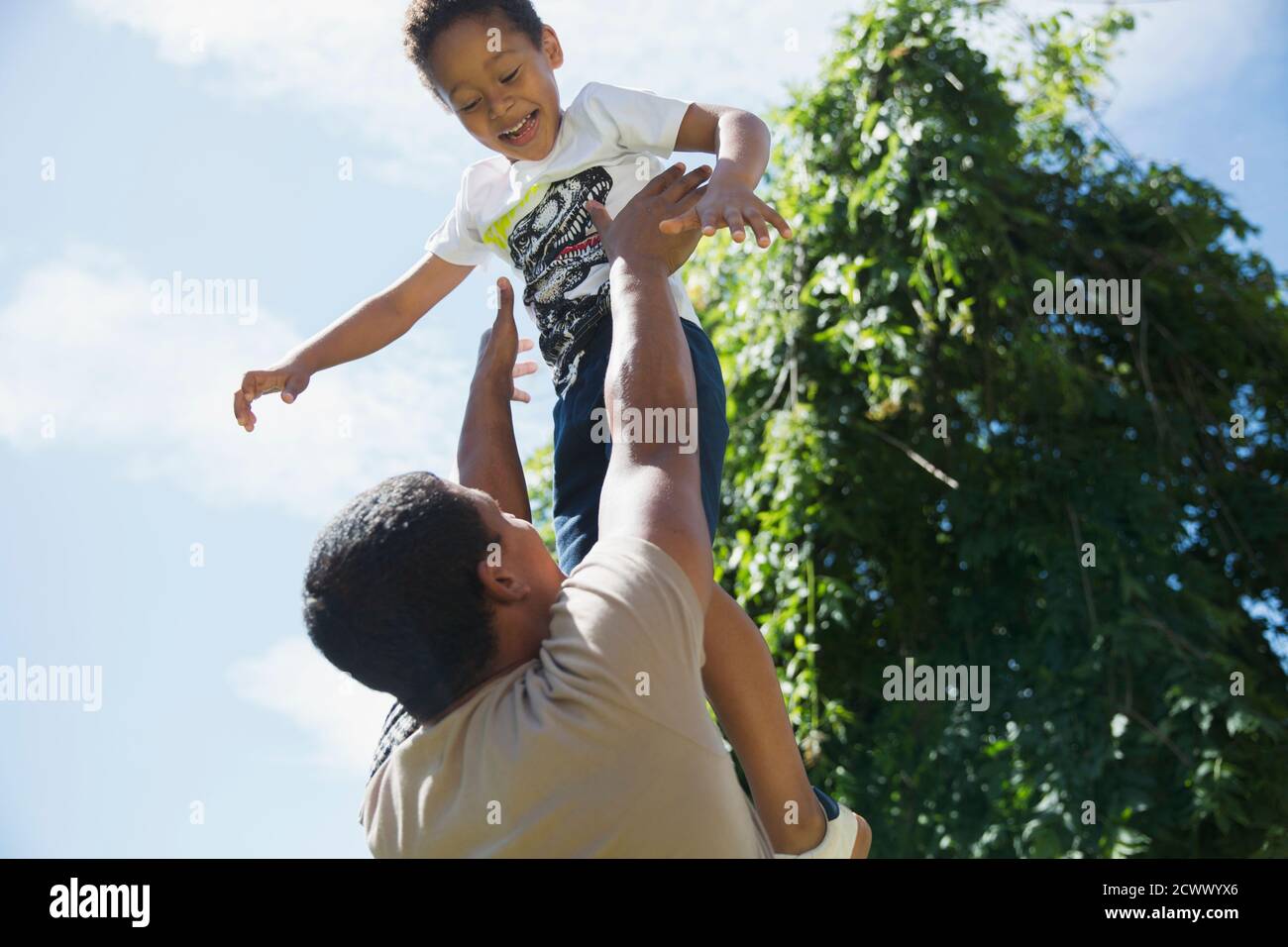 Un père qui jette son fils au soleil pour jouer Banque D'Images