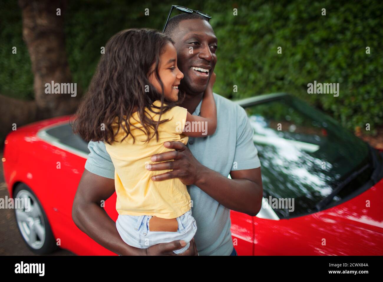 Père heureux tenant sa fille dehors convertible Banque D'Images