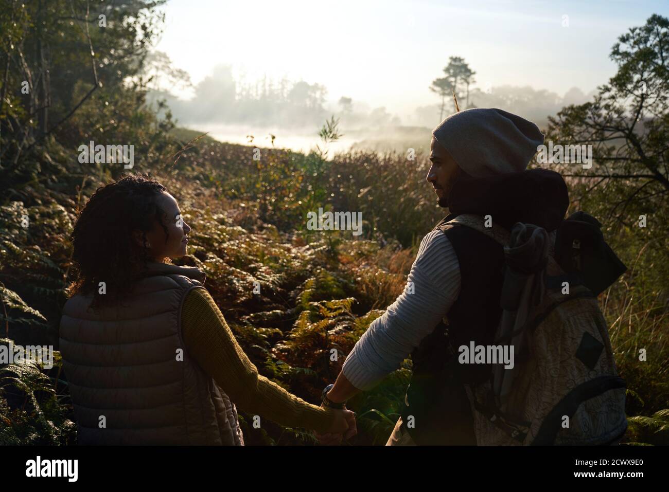 Jeune couple affectueux tenant les mains et faisant de la randonnée dans la nature Banque D'Images
