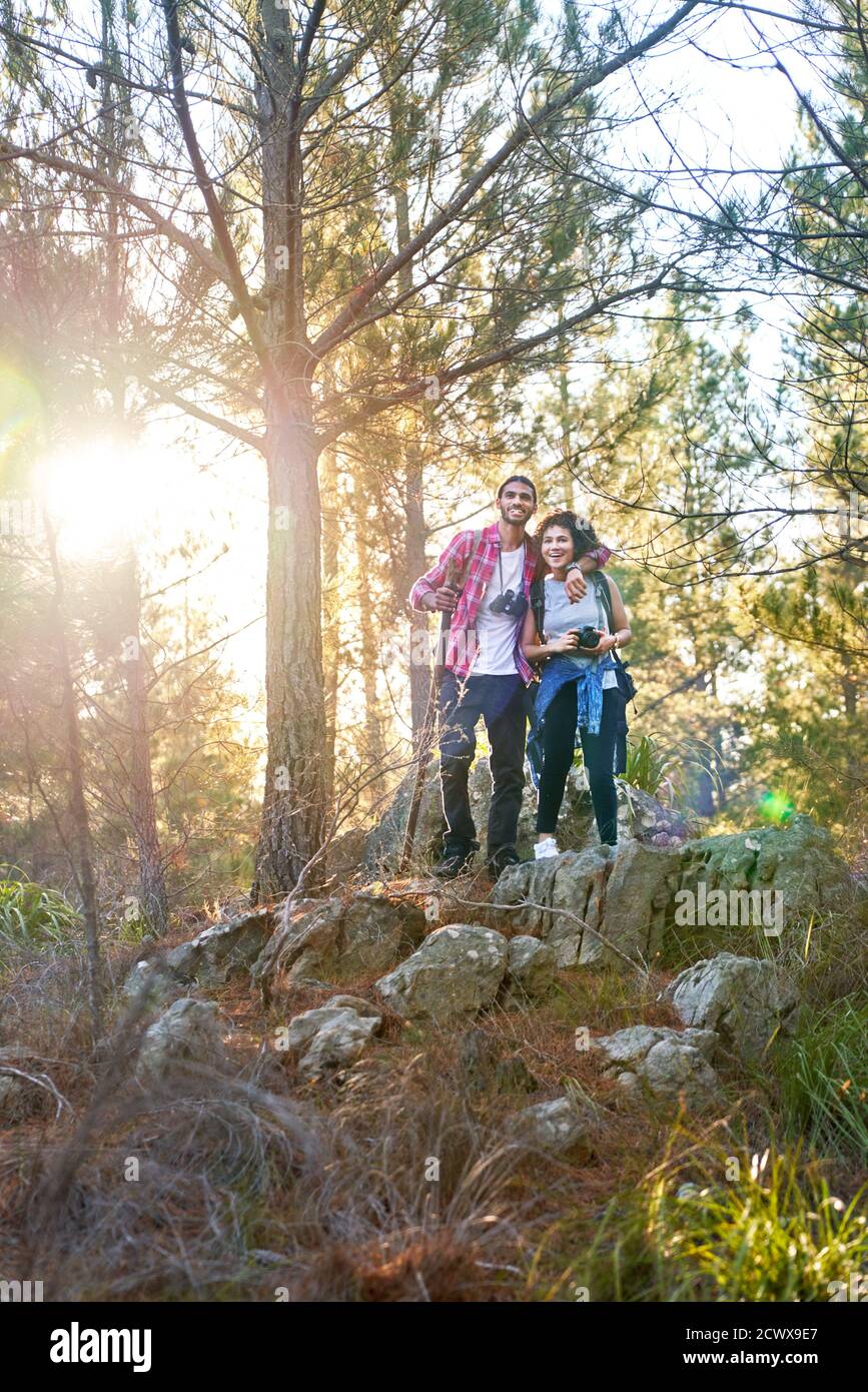 Joyeux jeune couple randonnée dans des bois ensoleillés Banque D'Images