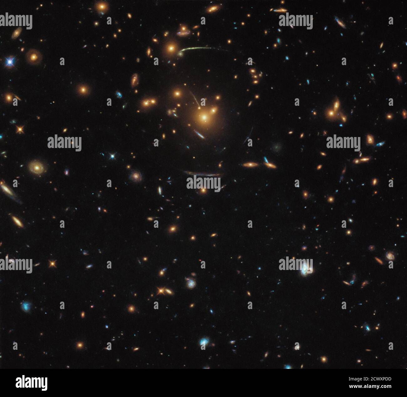 Vue déformée de l’Univers de Hubble cette image du télescope spatial Hubble NASA/ESA contient un véritable mélange de différentes galaxies, dont certaines appartiennent à la même structure plus grande : au milieu du cadre se trouve le groupe de galaxies SDSS J1050+0017. La masse gigantesque de cette grappe crée le phénomène fascinant de la forte attraction gravitationnelle. La gravité de l'amas fait plier la lumière venant de l'arrière de la machine de la même manière que la base d'un verre à vin plie la lumière. Les effets de ce lensing peuvent être clairement vus comme des stries courbes formant une forme circulaire autour du centre du cadre. Astr Banque D'Images