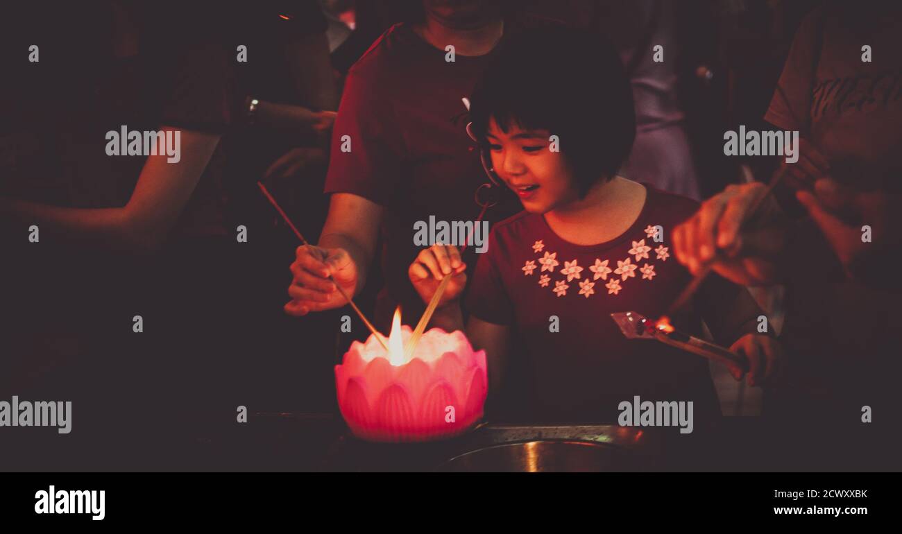 La jeune fille asiatique éclaire des bâtons traditionnels lors de la célébration du nouvel an chinois Banque D'Images