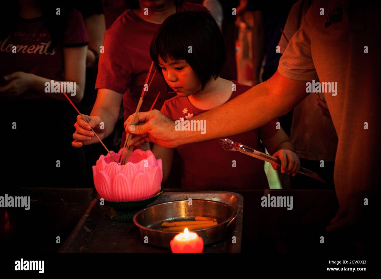 La jeune fille asiatique éclaire des bâtons traditionnels lors de la célébration du nouvel an chinois Banque D'Images