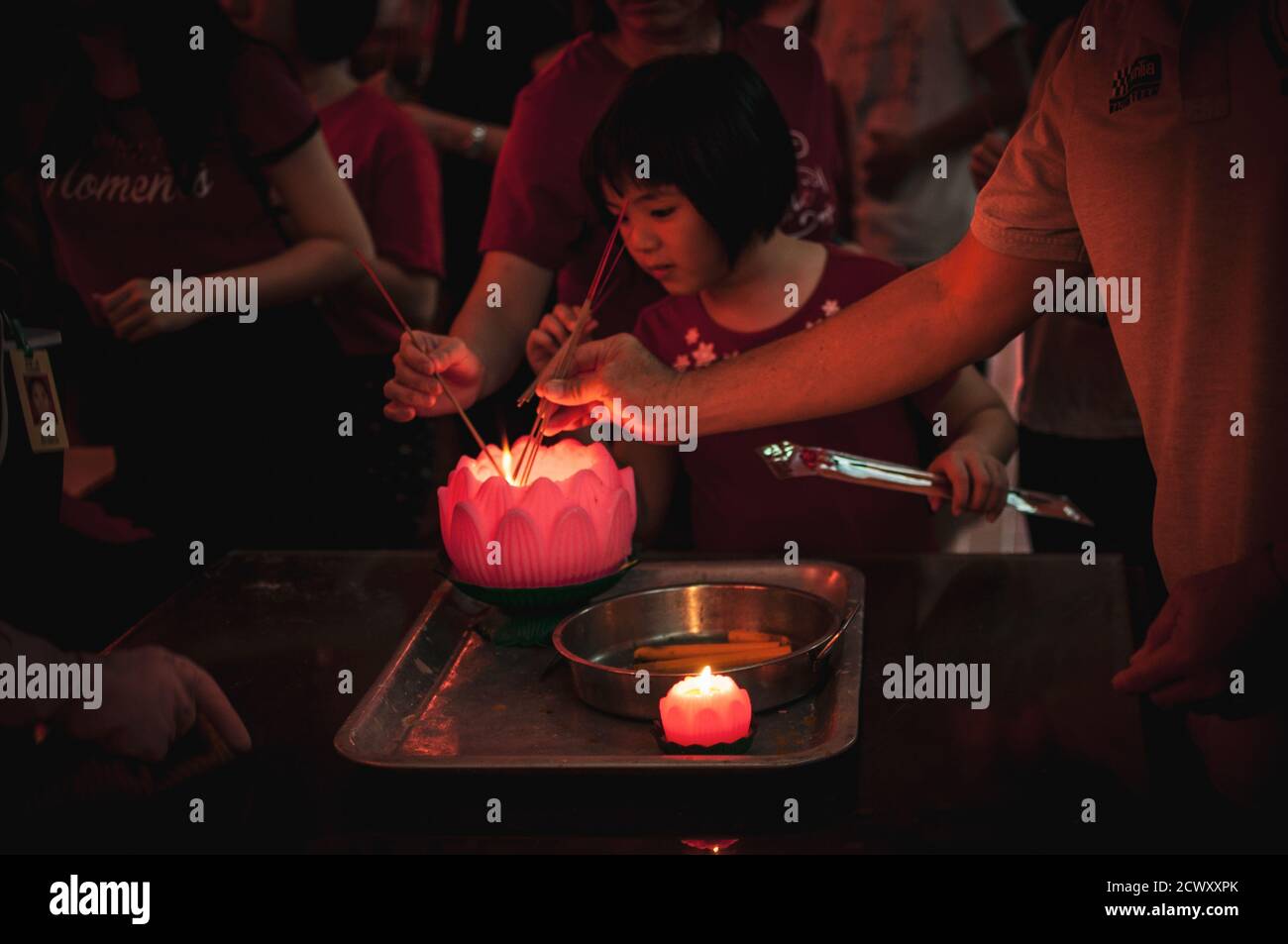 La jeune fille asiatique éclaire des bâtons traditionnels lors de la célébration du nouvel an chinois Banque D'Images