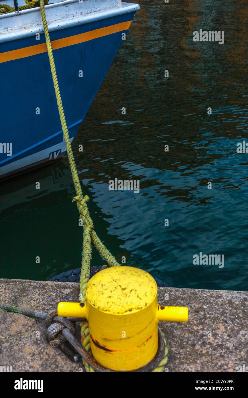 Bateau ancré avec une corde d'amarrage attachée à un bollard. Tir vertical Banque D'Images