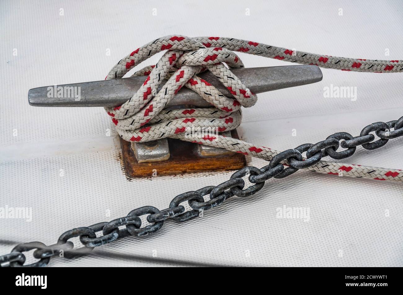 Gros plan de la cale du bateau avec une chaîne et une corde attachée autour. Concept visuel de connexion comme bateau attaché et lié au ponton. Banque D'Images