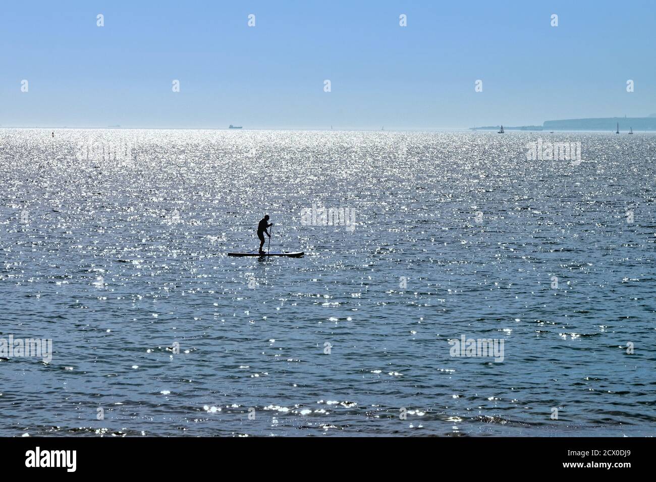 Silhouette d'un pédalo sur le Solent sur un summers Hayling Island Hampshire Angleterre Royaume-Uni Banque D'Images