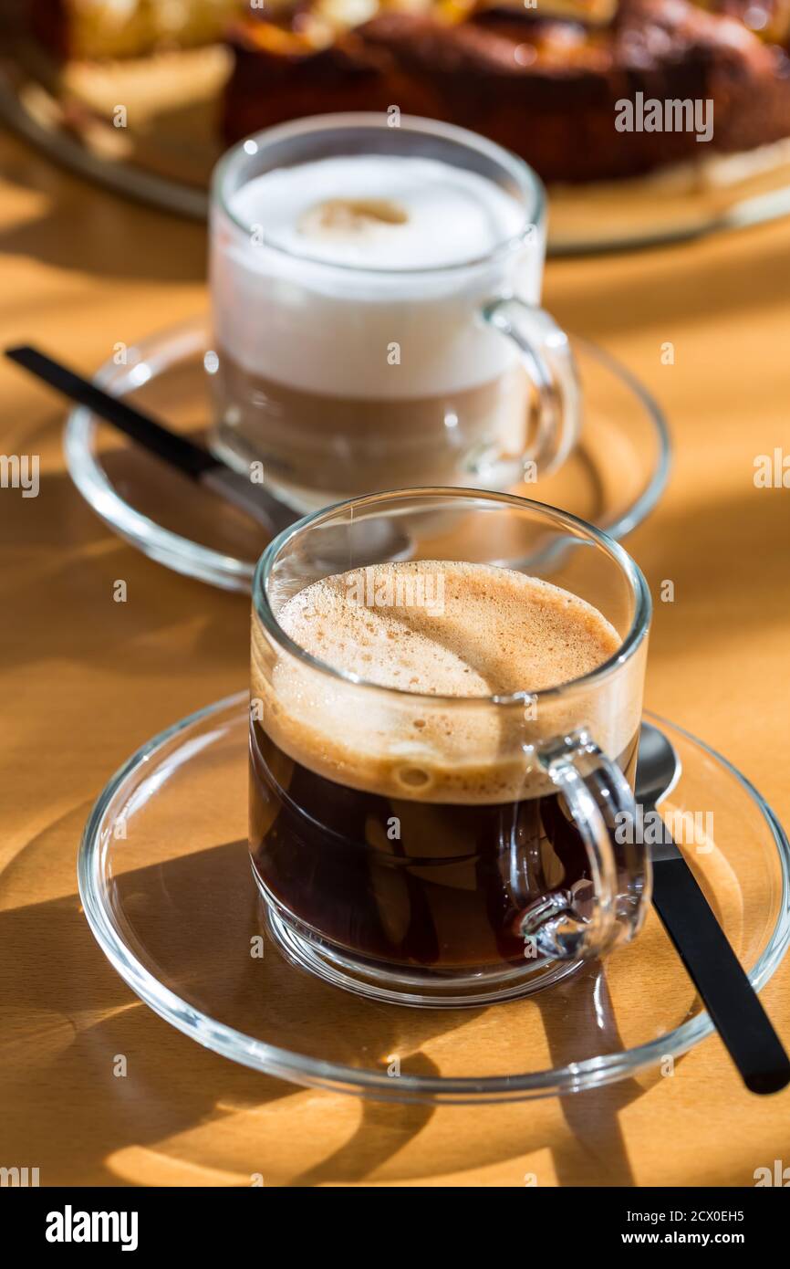 Deux tasses de café et de cappuccino avec gâteau sur une table en bois. Banque D'Images