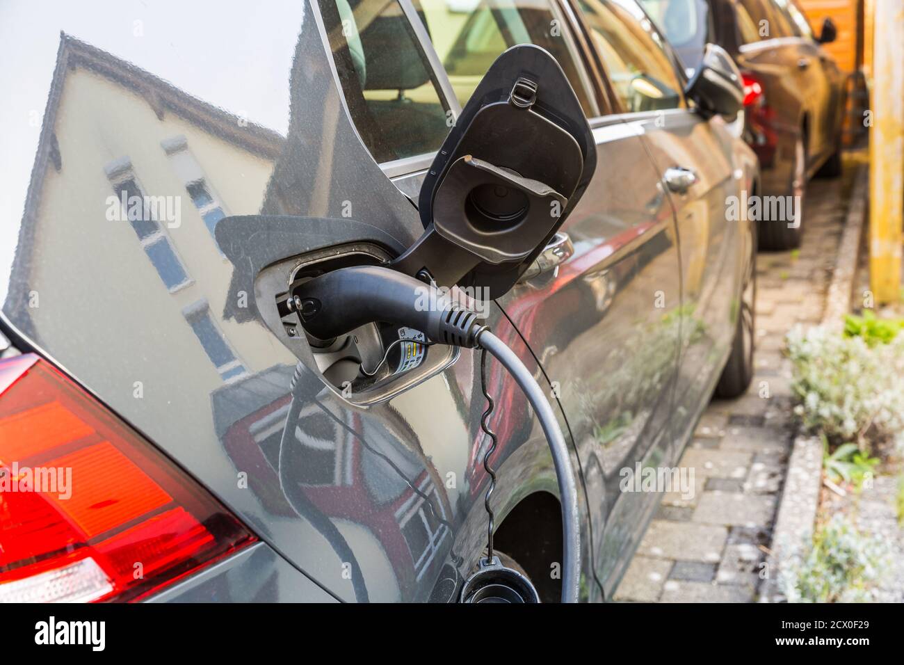 Une voiture électrique de charge avec le cordon d'alimentation branché. Banque D'Images