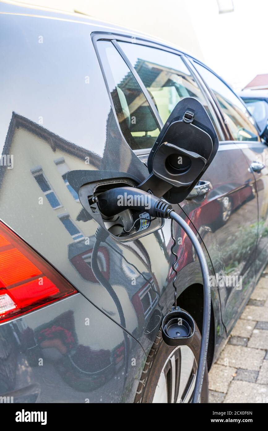 Une voiture électrique de charge avec le cordon d'alimentation branché. Banque D'Images