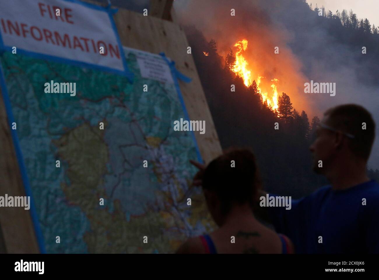 Les gens regardent une carte du feu alors que les flammes sautent au