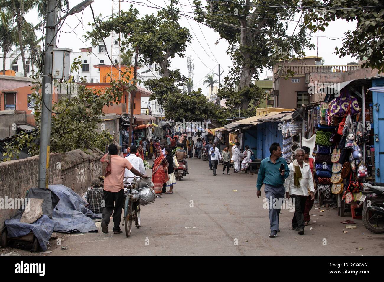 Puri, Inde - 3 février 2020 : quelques personnes non identifiées se promène sur une petite route asphaltée locale à côté des magasins le 3 février 2020 à Puri, Inde Banque D'Images