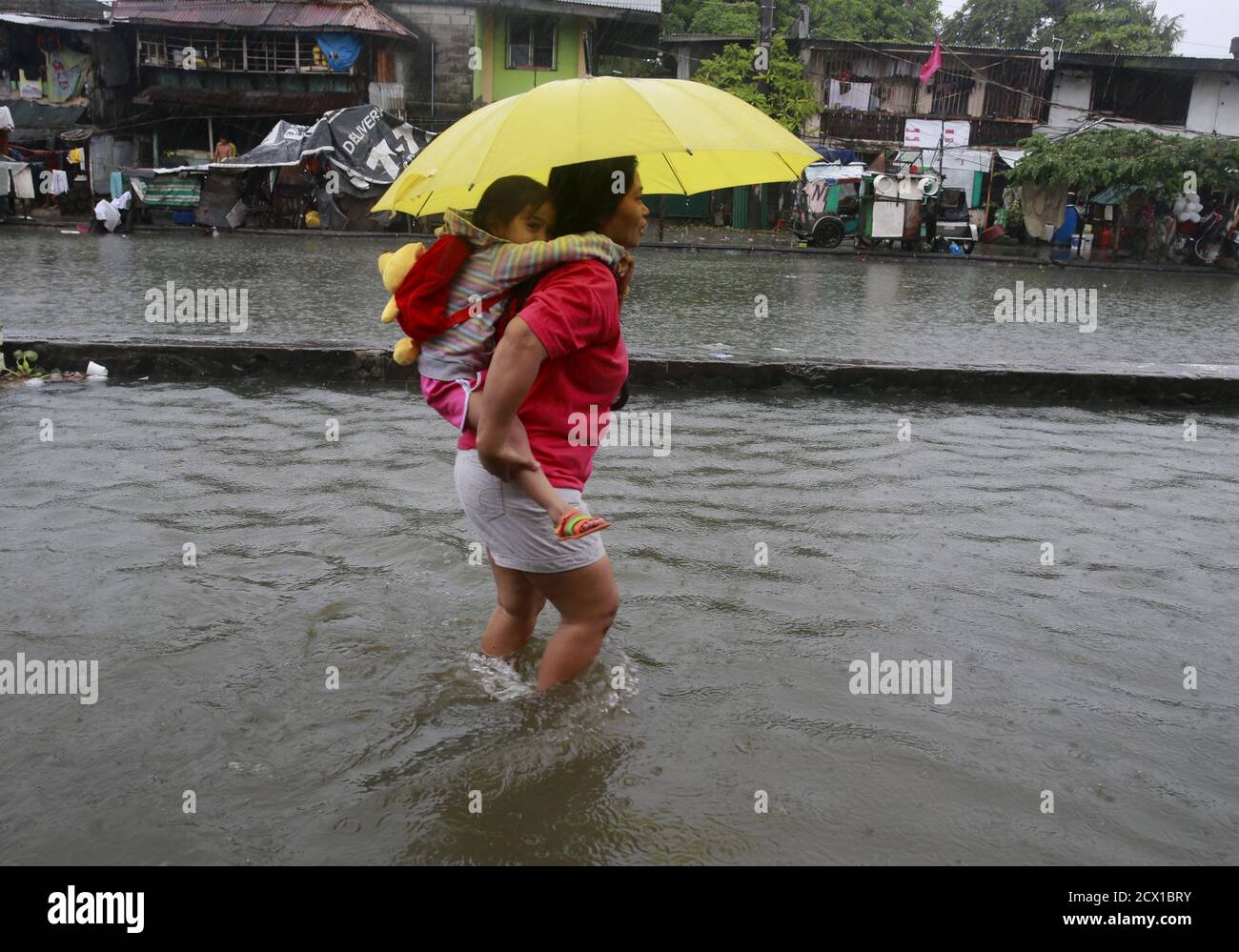 Une mère transporte sa fille dans les eaux d'inondation profondes des  genoux, causées par le typhon Chan-Hom, dans la ville de Pinagsabugan, dans  la ville de Malabo, au nord de Manille, le