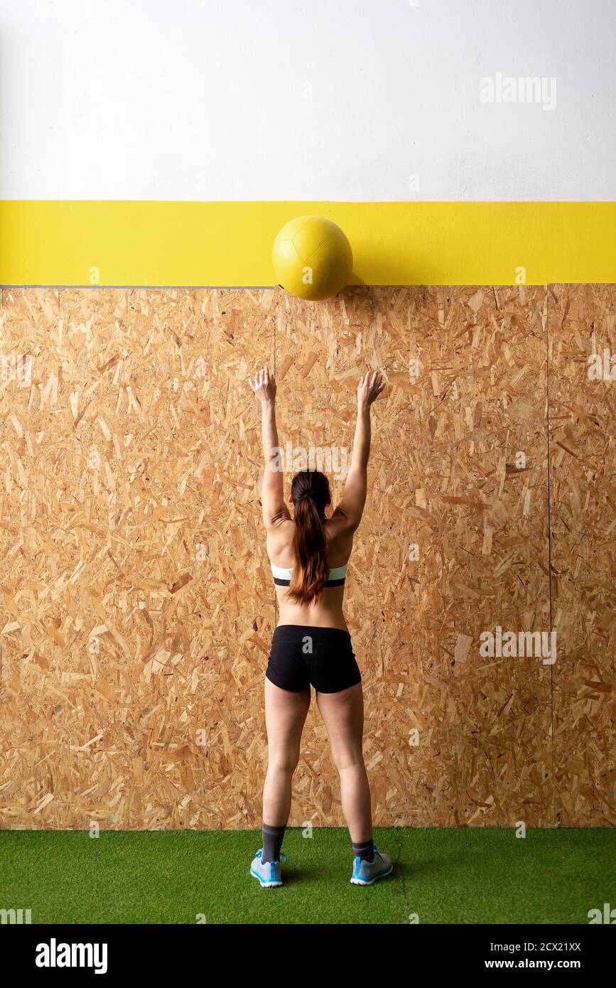 Vue arrière d'un jeune athlète magnifique avec queue de cheval ballon de  cuir lourd au mur de liège à la salle de gym Photo Stock - Alamy